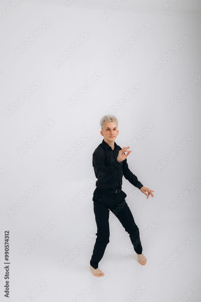 A man in black dances bachata, salsa, zouk, kizomba on a white background A man in black dances bachata, salsa, zouk, kizomba on a white background