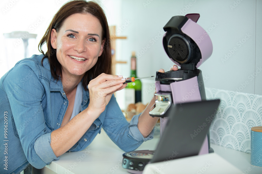woman repairing coffee machine in kitchen woman repairing coffee machine in kitchen