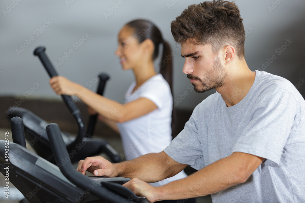 man setting up exercise cardio machine man setting up exercise cardio machine
