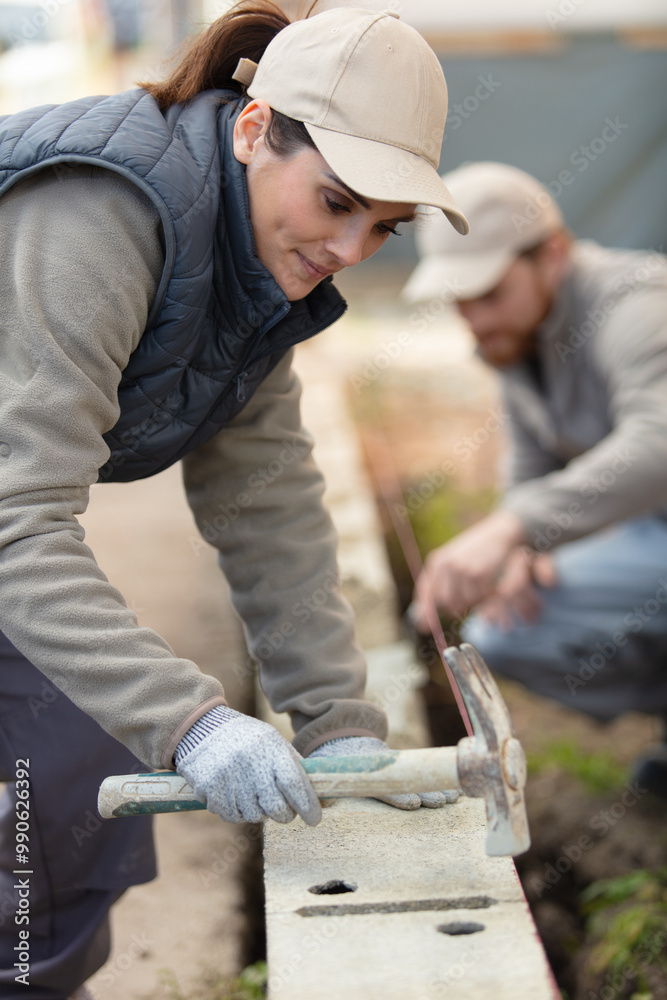 female construction worker on site hammering female construction worker on site hammering