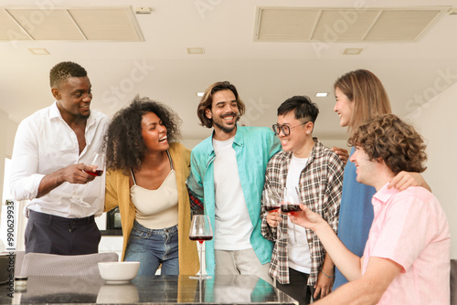 Joyful multi-racial friends having a conversation and laughing together at a dining table, smiling as they enjoy champagne in a warm and loving toast, sharing a moment of togetherness and celebration.