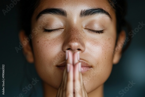 A serene woman with closed eyes in a meditative prayer pose, embracing calm and mindfulness.