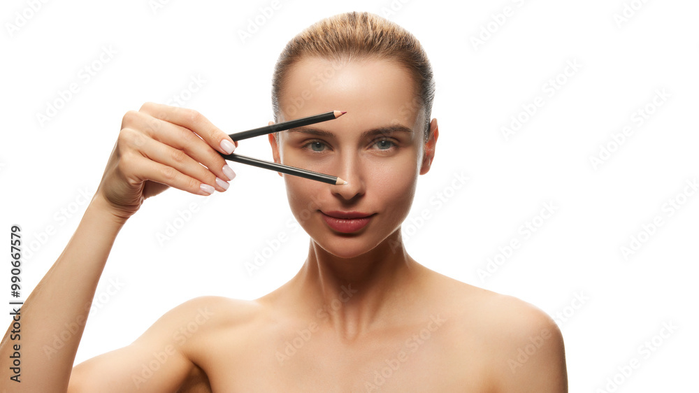 Portrait of young beautiful woman posing with two makeup pencil for eyes and lips isolated on white studio background. Concept of natural female beauty, skin care, cosmetics and cosmetology Portrait of young beautiful woman posing with two makeup pencil for eyes and lips isolated on white studio background. Concept of natural female beauty, skin care, cosmetics and cosmetology