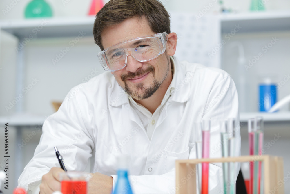 smiling male chemist working in laboratory smiling male chemist working in laboratory