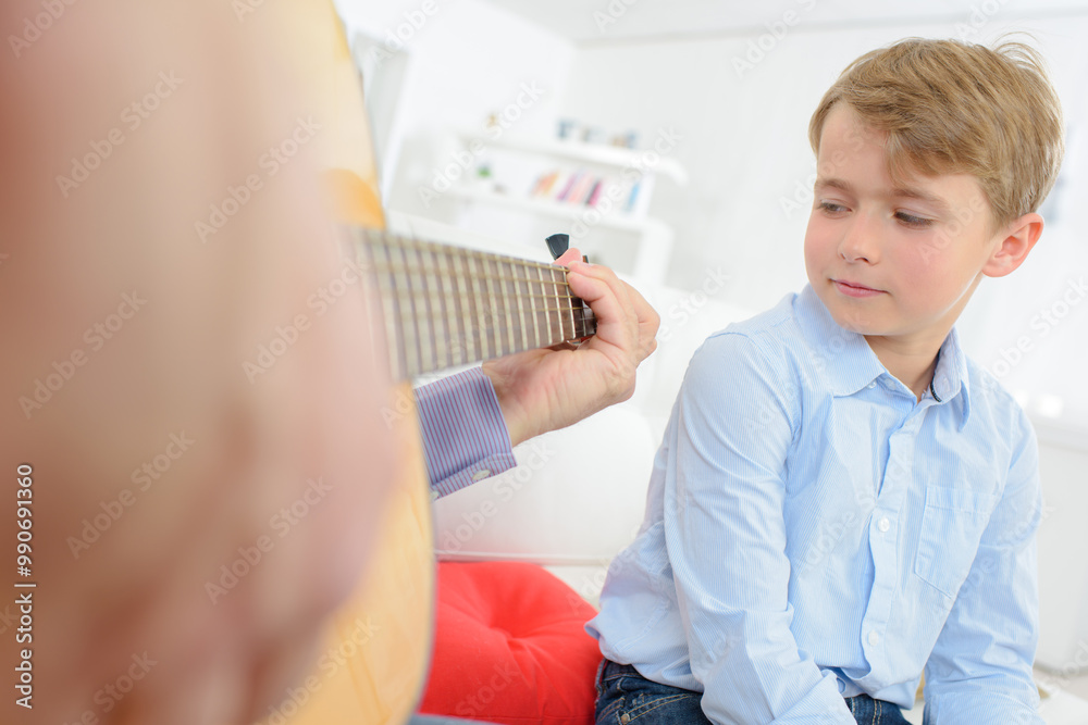 Child watching adult play guitar Child watching adult play guitar