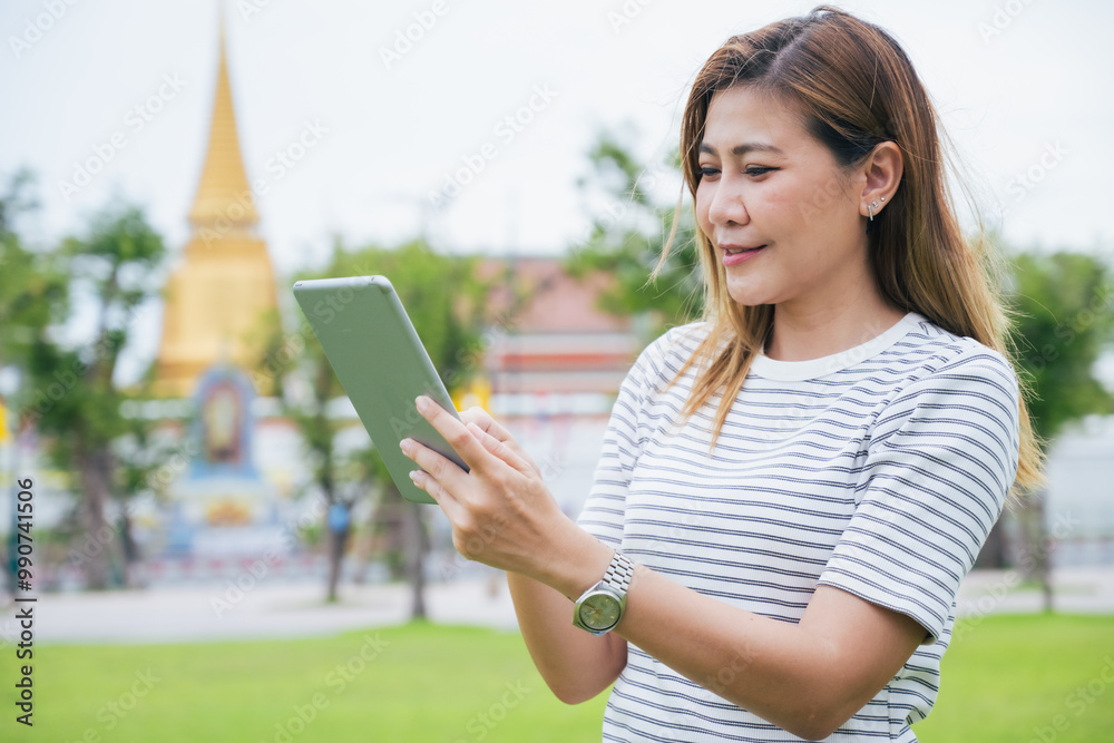 The group of South Asian tourists holding a map and searching for directions, with the iconic Wat Phra Kaew temple in the background in Bangkok, Thailand, enjoying their holiday adventure. The group of South Asian tourists holding a map and searching for directions, with the iconic Wat Phra Kaew temple in the background in Bangkok, Thailand, enjoying their holiday adventure.