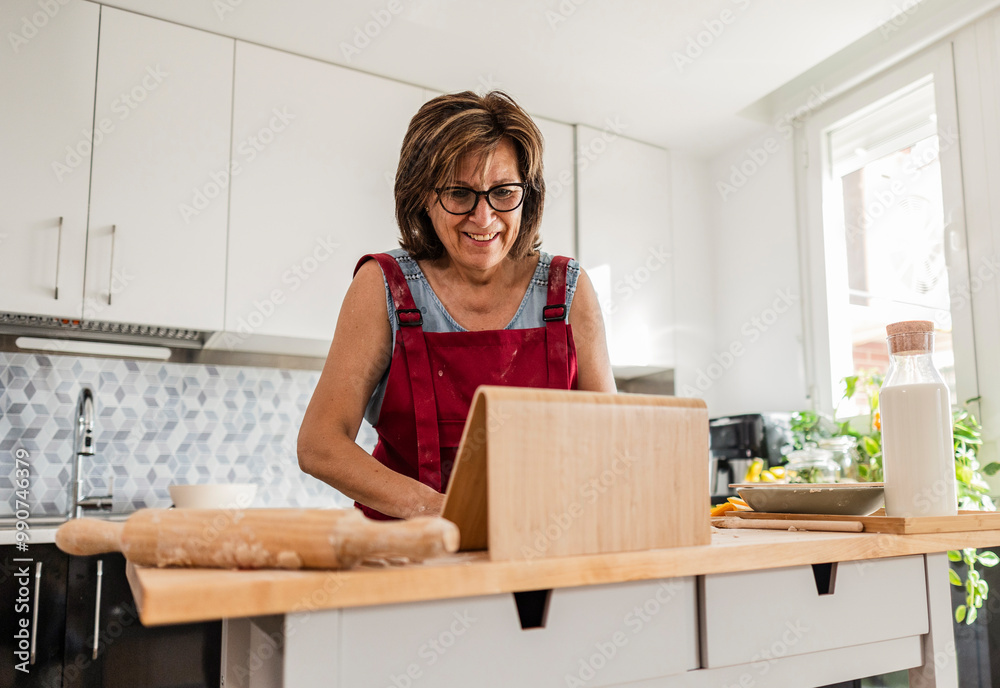 Grandmother using tablet for recipe in kitchen Grandmother using tablet for recipe in kitchen