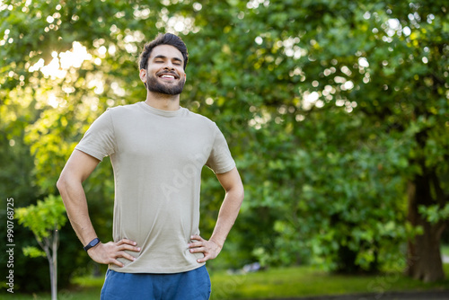 Photography Photo of a smiling young Indian man standing in the park with his eyes closed, h