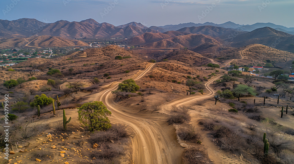 Scenic Dirt Road Winding Through Hilly Terrain in a Desert Landscape During Late Afternoon Scenic Dirt Road Winding Through Hilly Terrain in a Desert Landscape During Late Afternoon
