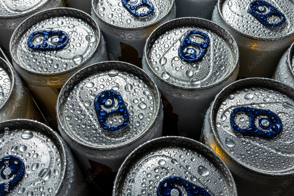 Close-up of multiple aluminum beverage cans covered in water droplets. The cans feature blue pull tabs and condensation, emphasizing coldness and refreshment. Close-up of multiple aluminum beverage cans covered in water droplets. The cans feature blue pull tabs and condensation, emphasizing coldness and refreshment.