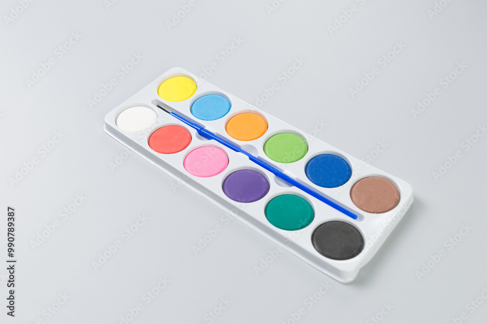 Top view of watercolor and paint brush on grey background. Painting, art, copy space, flat lay.
