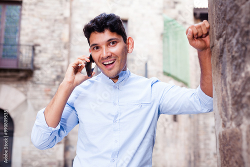 Modern guy walks in city and communicates on smartphone photo