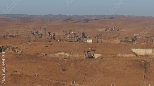 Aerial view of the oil rigs and wells in the Midway-Sunset shale oil fields, the largest in California. A pumpjack operates at an oil field. Oil pump rig energy industrial machine for petroleum.