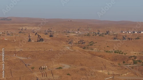 Aerial view of the oil rigs and wells in the Midway-Sunset shale oil fields, the largest in California. A pumpjack operates at an oil field. Oil pump rig energy industrial machine for petroleum.