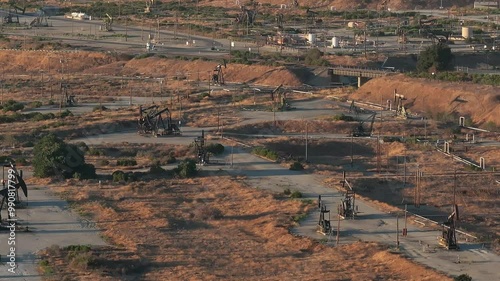Aerial view of the oil rigs and wells in the Midway-Sunset shale oil fields, the largest in California. A pumpjack operates at an oil field. Oil pump rig energy industrial machine for petroleum.