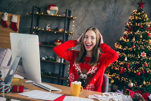 Photo of nice young girl work computer excited amazed wear christmas clothes enjoy modern cozy x-mas party decoration interior flat indoors photo