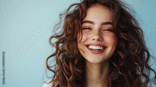 Gorgeous brunette model with long, curly hair who laughs a lot. woman with wavy curls and a smile. A portrait of fashion, beauty, and makeup photo