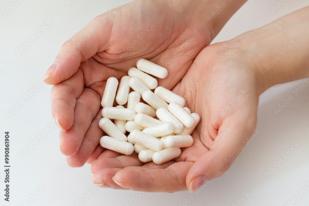 Treatment concept. Woman's hands full of white medical pills on white background. Healthcare concept. pharmaceutical medicaments. Vitamin supplements. Heap of pills in female hands Treatment concept. Woman's hands full of white medical pills on white background. Healthcare concept. pharmaceutical medicaments. Vitamin supplements. Heap of pills in female hands