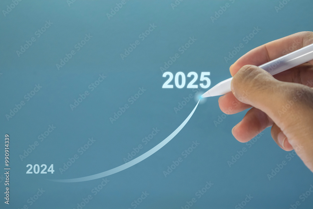 Hand holding a pen making a growth line from 2024 to 2025. Turn of the new year. New year's resolution. Hand holding a pen making a growth line from 2024 to 2025. Turn of the new year. New year's resolution.