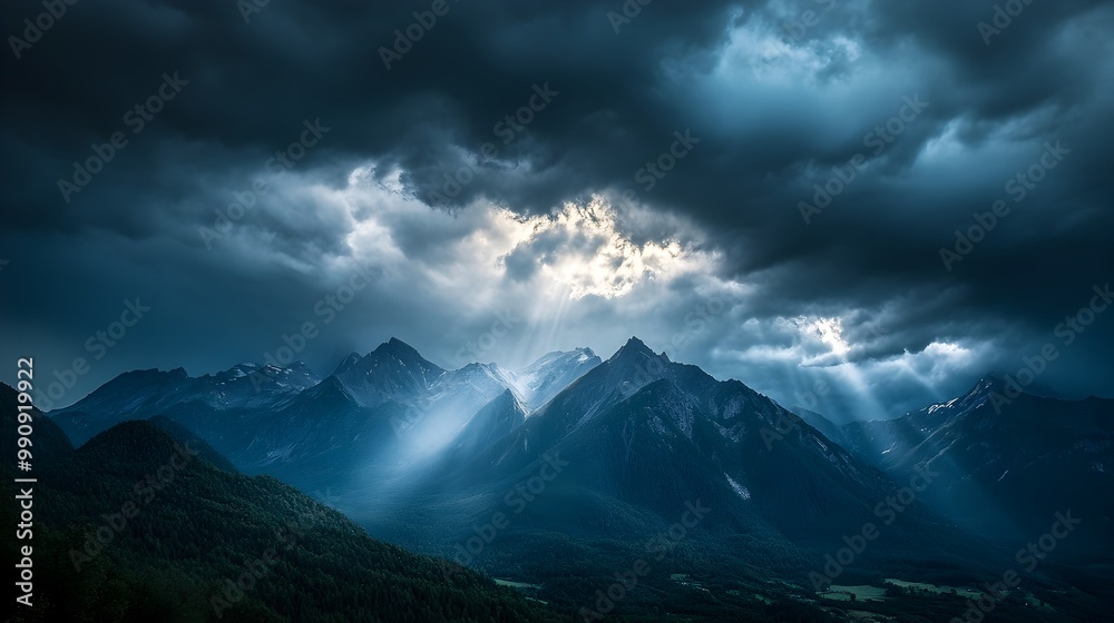 Fototapeta premium Ominous dark storm clouds gathering overhead cast a dramatic foreboding atmosphere over the majestic mountain range The light highlights the rugged towering peaks