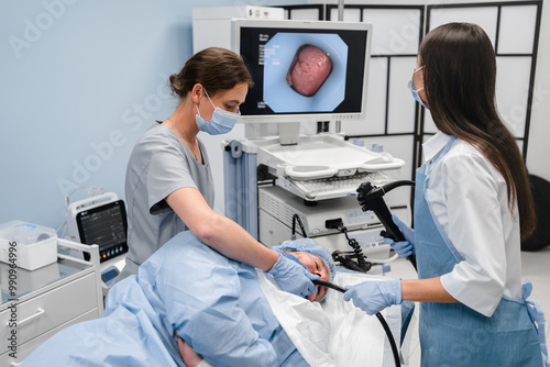 Doctor using a fiberoptic scope at gastroscopy in modern operating room. Gastroenterologist using endoscopic retrograde cholangial pancreatography in gall stone patient with abdominal pain.