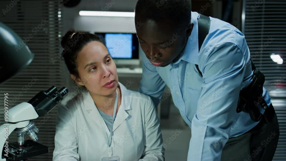Tilt up shot of female forensic scientist commenting on evidence test ...