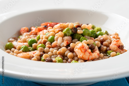 Fregula sarda con pisellini e gamberi, pasta italiana, ricetta mediterranea  photo