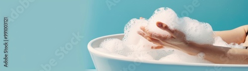 Side view of a person enjoying a bubble bath, with a focus on hands playing with foam. Relaxing bath time concept against a serene blue background.