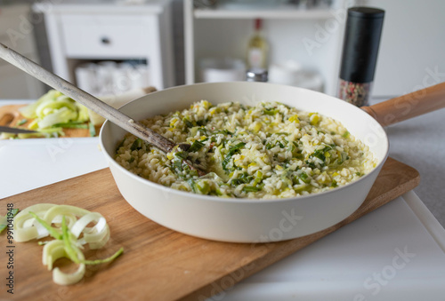 Italian homemade leek rissotto. Ready to eat in a skillet on kitchen counter background. photo