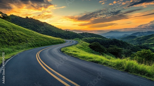 A winding road through lush green hills under a vibrant sunset sky.