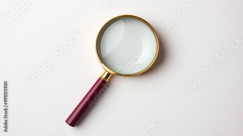Elegant Gold and Burgundy Magnifying Glass on White Surface - Precision Tool for Investigation and Clarity