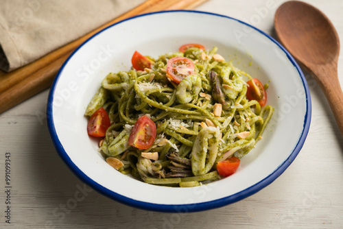 Fresh spaghetti with green pesto and calamari. Traditional Italian recipe.