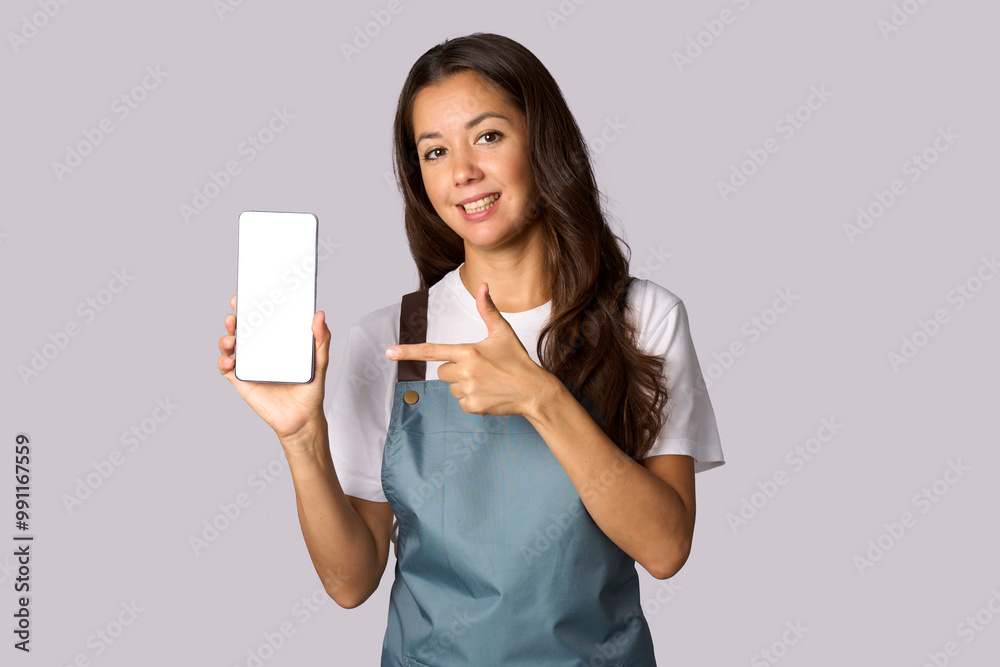 Happy woman wearing apron showing the smartphone white screen, shopping concept Happy woman wearing apron showing the smartphone white screen, shopping concept