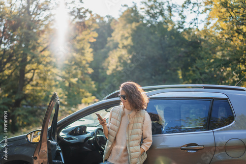 Young beautiful woman traveling by car using smartphone , vacation and adventure
