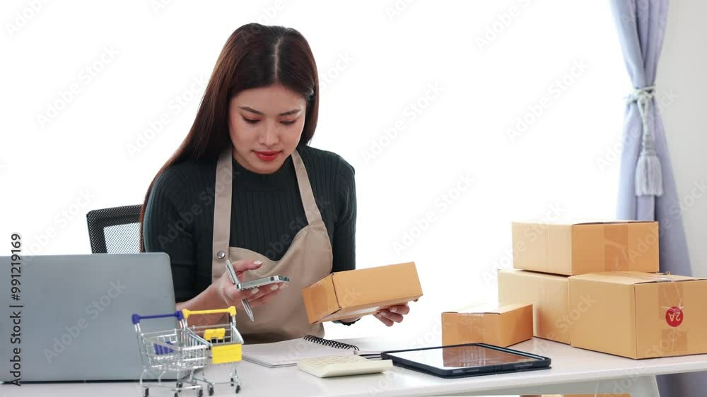A successful Asian businesswoman running her online business, packaging her online orders, she efficiently handles shipping, warehousing and sales, while providing excellent customer service. A successful Asian businesswoman running her online business, packaging her online orders, she efficiently handles shipping, warehousing and sales, while providing excellent customer service.