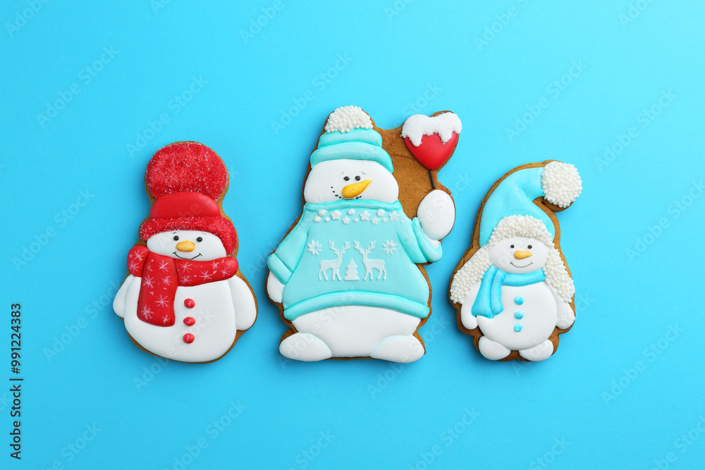 Tasty Christmas cookies in shape of snowman on light blue background, flat lay Tasty Christmas cookies in shape of snowman on light blue background, flat lay
