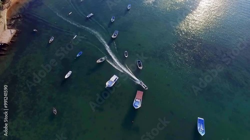 Drone view of boats and a speedboat crossing the calm sea near Orla Bardot, Búzios. photo