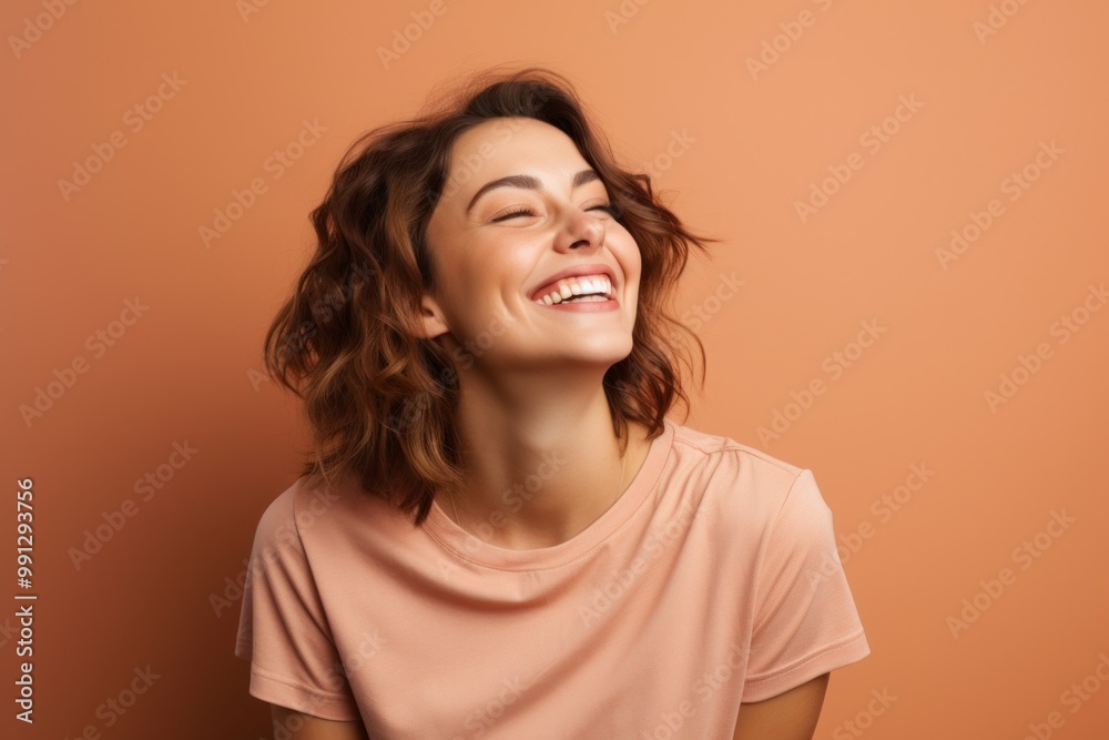 Portrait of a joyful woman in her 20s dressed in a casual t-shirt over soft brown background Portrait of a joyful woman in her 20s dressed in a casual t-shirt over soft brown background