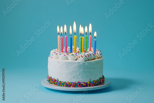 Colorful birthday cake with lit candles and sprinkles, set against a bright pastel blue background