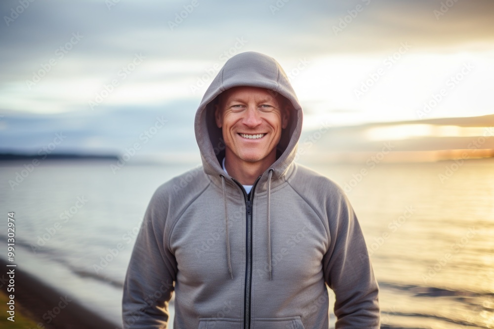 Portrait of a grinning man in his 40s sporting a comfortable hoodie in serene seaside background Portrait of a grinning man in his 40s sporting a comfortable hoodie in serene seaside background