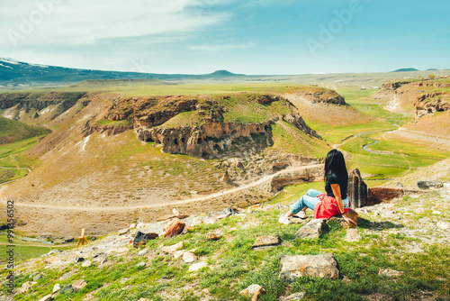 Young caucasian woman stand enjoy travel and viewpoint in Turkey eastern anatolia- Ani ruins site photo