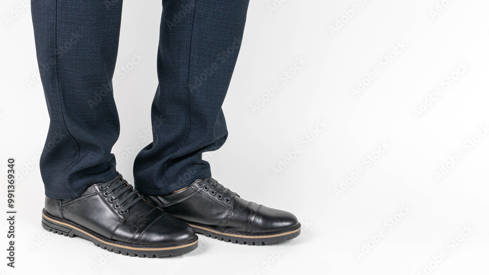 Close-Up of Businessman's Legs in Formal Pants and Black Leather Shoes on White Background Close-Up of Businessman's Legs in Formal Pants and Black Leather Shoes on White Background