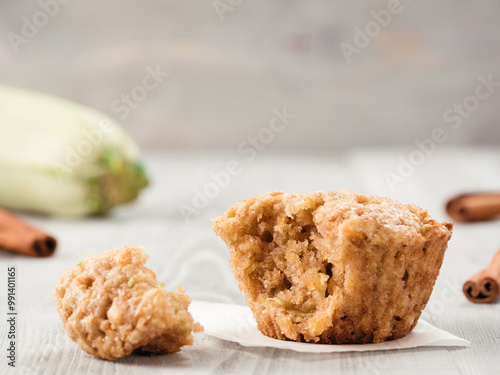 Close up view of muffin with zucchini, carrots, apple and cinnamon on gray wooden background. Sweet vegetables homemade muffins. Toddler-friendly recipe idea. Copy space. Shallow DOF