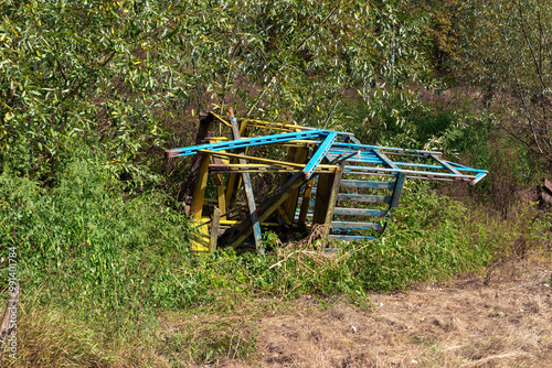 A broken wooden slide at an abandoned playground