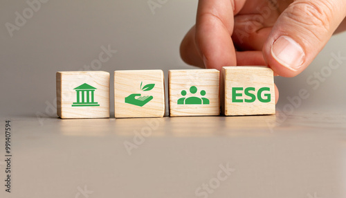 ESG Concept with Wooden Cubes Displaying Environmental, Social, and Governance Icons, Hand Arranging Sustainability Symbols for Corporate Responsibility and Ethical Business Practices.