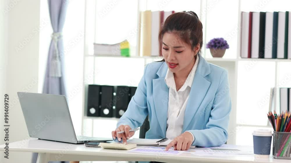 Confident Japanese businesswoman sitting at desk typing on laptop, using wireless technology in modern office environment, demonstrating professionalism and success. Confident Japanese businesswoman sitting at desk typing on laptop, using wireless technology in modern office environment, demonstrating professionalism and success.