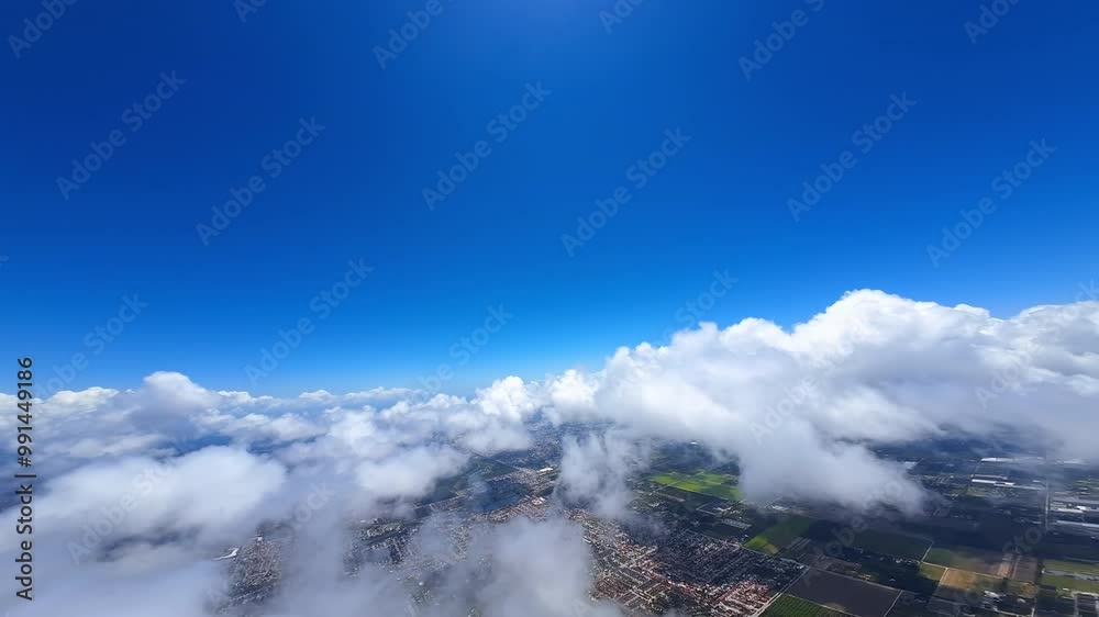 Stunning white cloudscape in the azure sky. FPV drone moving above the clouds opening view on the urban landscape on the ground. Stunning white cloudscape in the azure sky. FPV drone moving above the clouds opening view on the urban landscape on the ground.