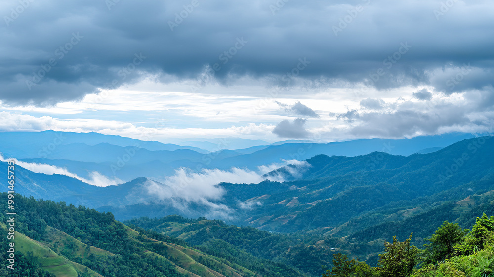 Obraz premium Amazing wild nature view of layer of mountain forest landscape with cloudy sky. Natural green scenery of cloud and mountain slopes background 