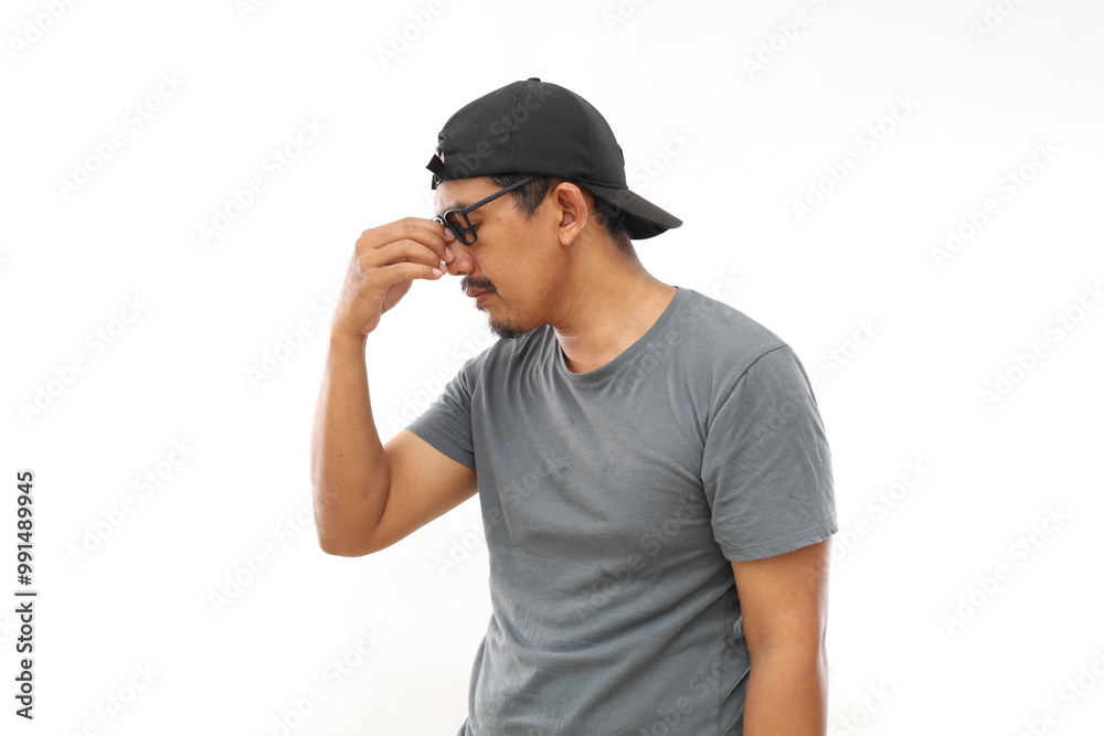Tired Asian man rubbing nose and eyes feeling fatigue and headache. Isolated on white Tired Asian man rubbing nose and eyes feeling fatigue and headache. Isolated on white
