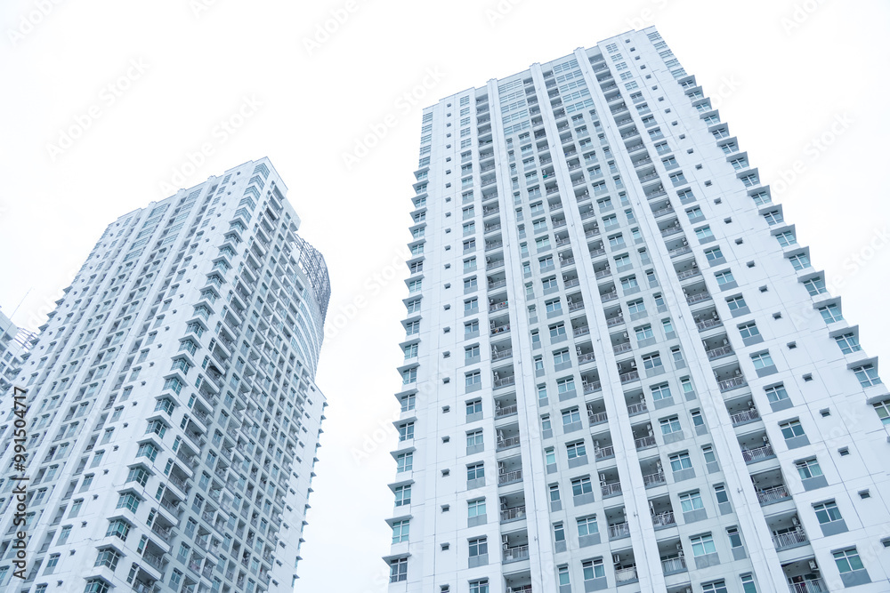 Low angle photo of an apartment building or high-rise residential building in the Pluit area, North Jakarta, Indonesia with bright sky background. Empty blank copy text space Low angle photo of an apartment building or high-rise residential building in the Pluit area, North Jakarta, Indonesia with bright sky background. Empty blank copy text space